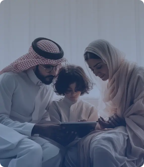عائلة تجلس على أريكة تنظر إلى جهاز لوحي في جو دافئ وهادئ